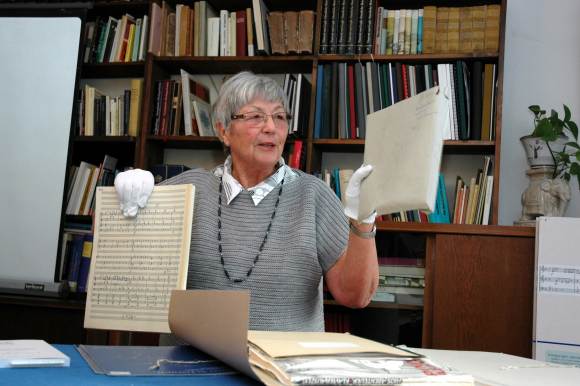Dr. Ina Iske-Schwaen zeigt Besuchern Noten und originale Handschriften von Kurt Schwaen